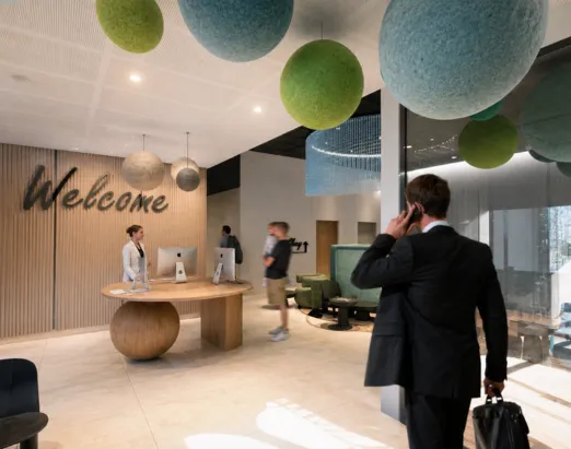 Accueil de l'hôtel 4 étoiles Ysotop à Grenoble avec son inscription Welcome et son desk en bois sculpté.
