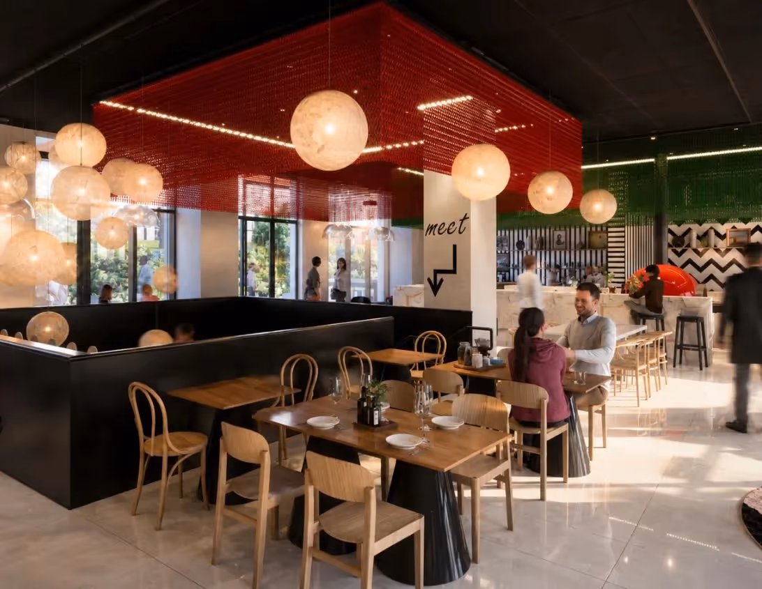 Salle à manger du restaurant Ysotop à Grenoble avec banquettes noires et plafond rouge aux suspensions nacrées.