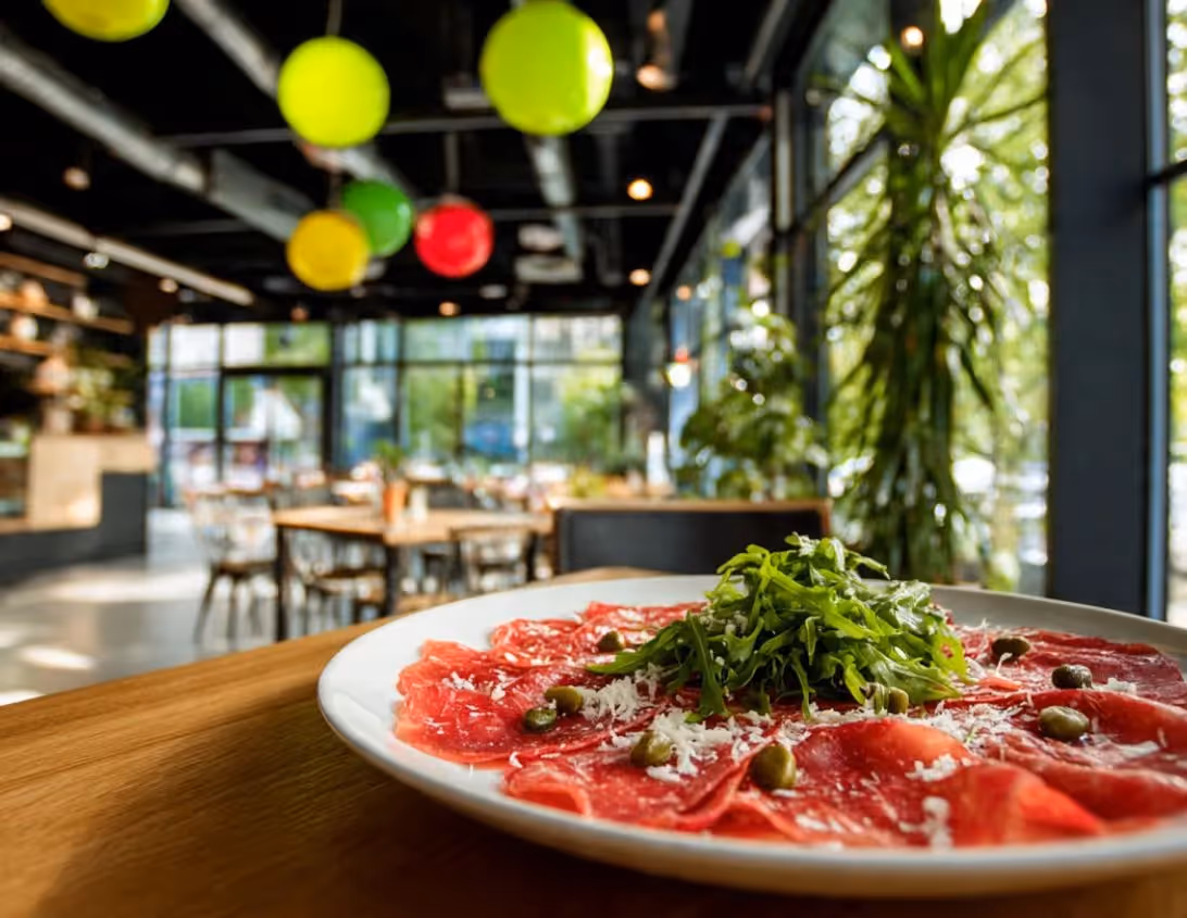 Carpaccio de bœuf aux câpres et parmesan dans la salle végétalisée du restaurant italien Ysotop à Grenoble.