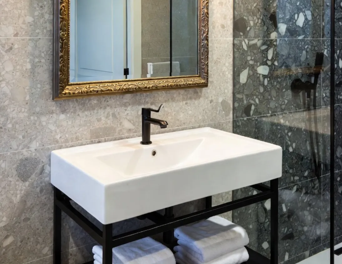 Bathroom with gold mirror, walk-in shower and square sink in the large studio hotel Ysotop Grenoble.
