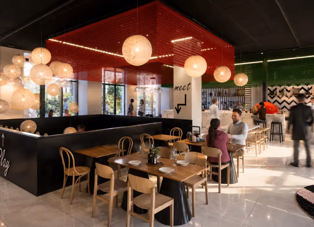 Large dining room at the Italian restaurant Ysotop in Grenoble, featuring a red ceiling and round, luminous pendant lights.