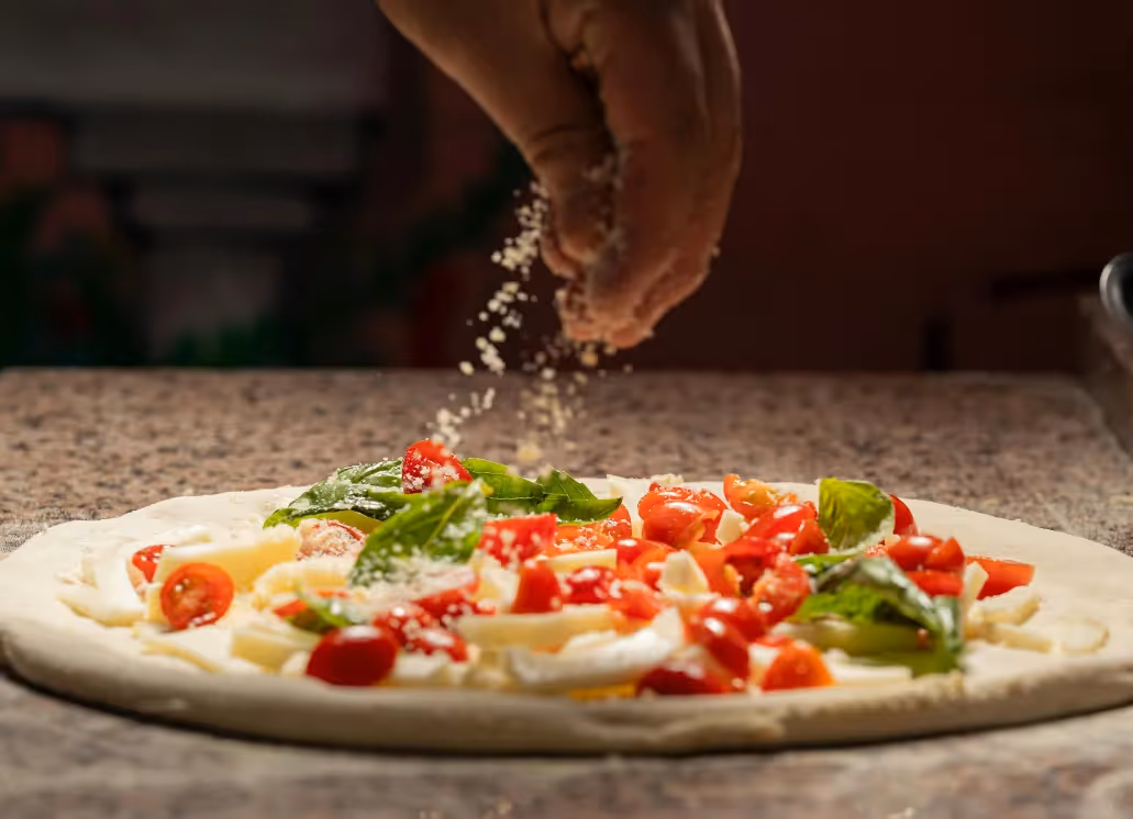 Preparing a homemade tomato, basil, and mozzarella pizza at the Italian restaurant of the Ysotop Hotel in Grenoble.