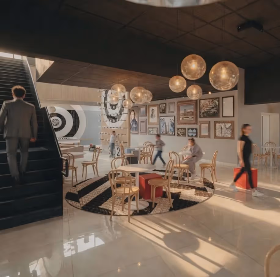 Espace commun animé de l'hôtel Ysotop à Grenoble avec galerie d'art et suspensions dorées au-dessus des tables en rotin.