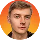 Portrait of a young man with short blond hair and light facial hair, orange gradient background.