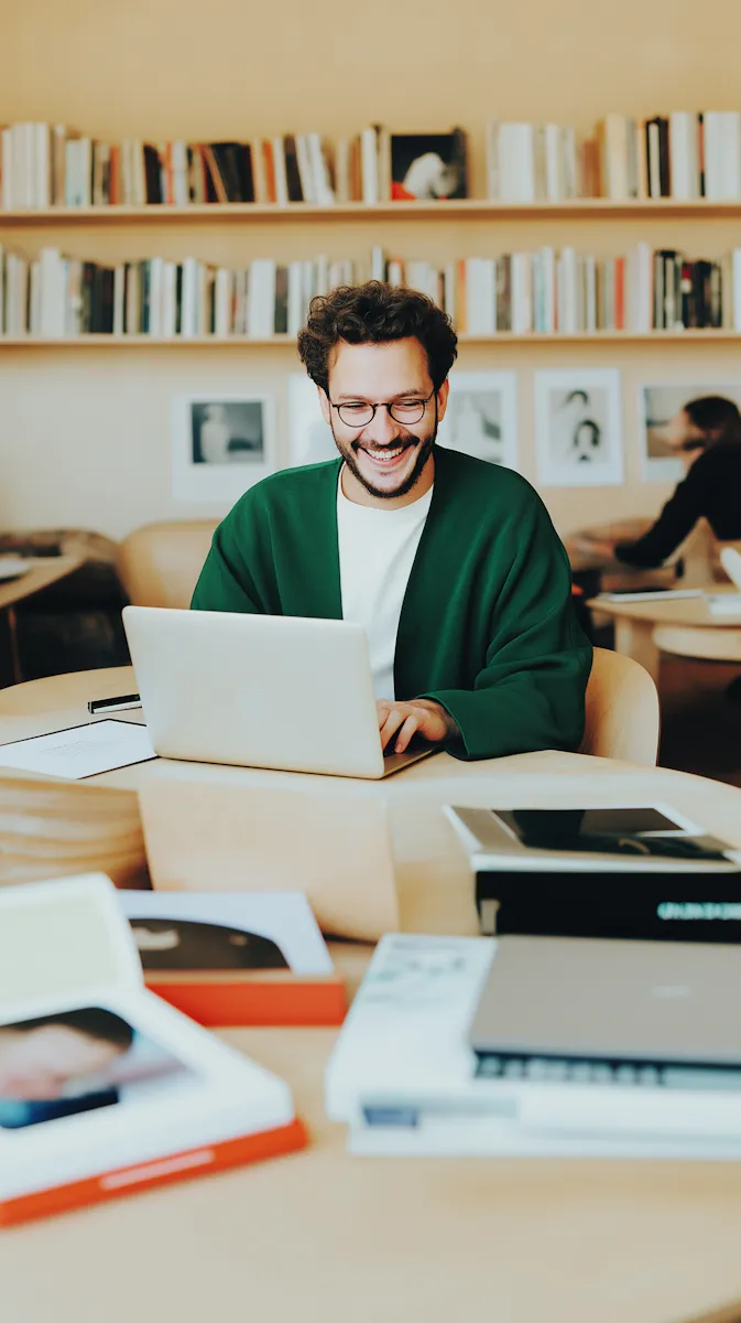 A man sitting at a table with a laptop.