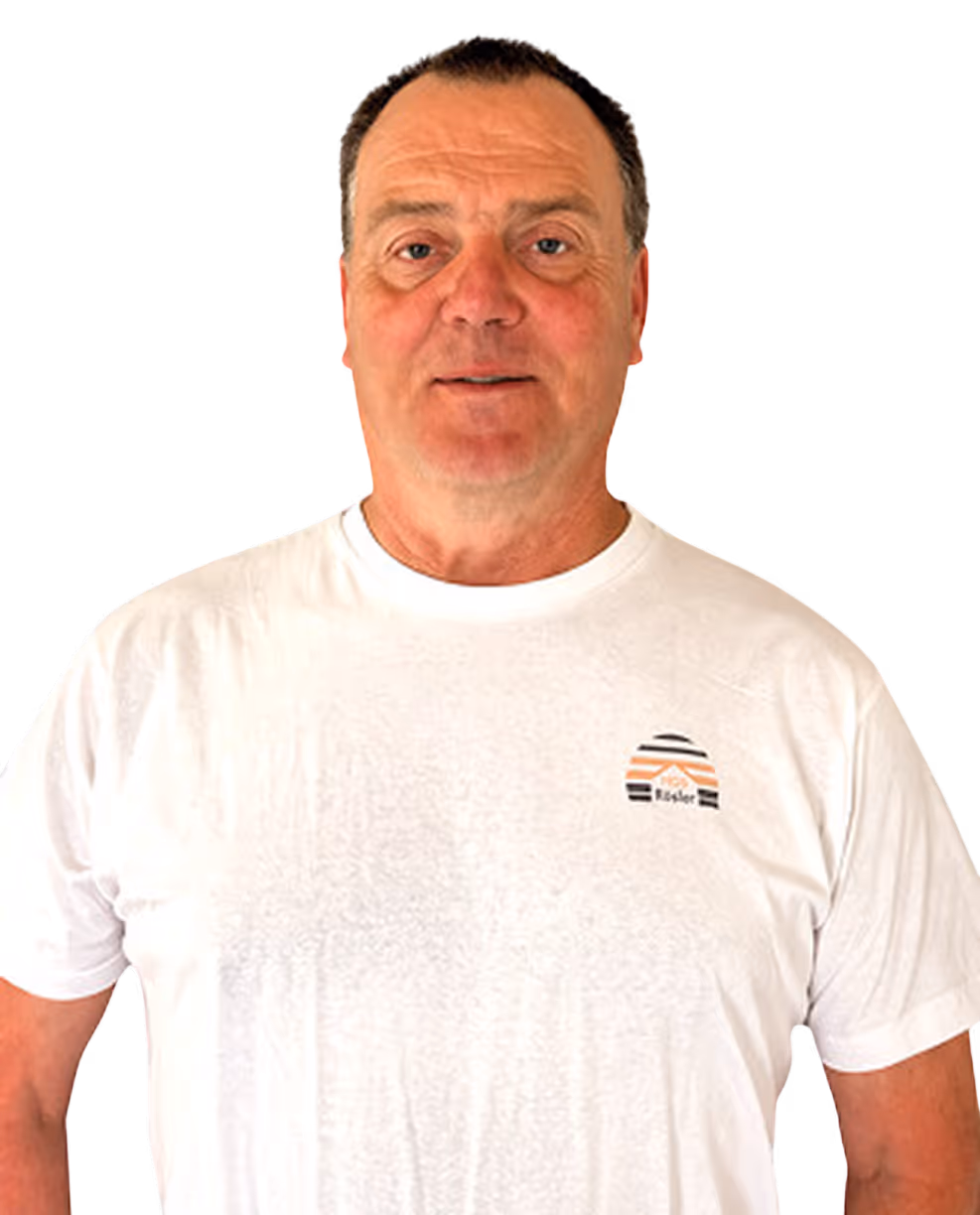 Mann mittleren Alters mit kurzen braunen Haaren, trägt ein weißes T-Shirt mit kleinem Logo.