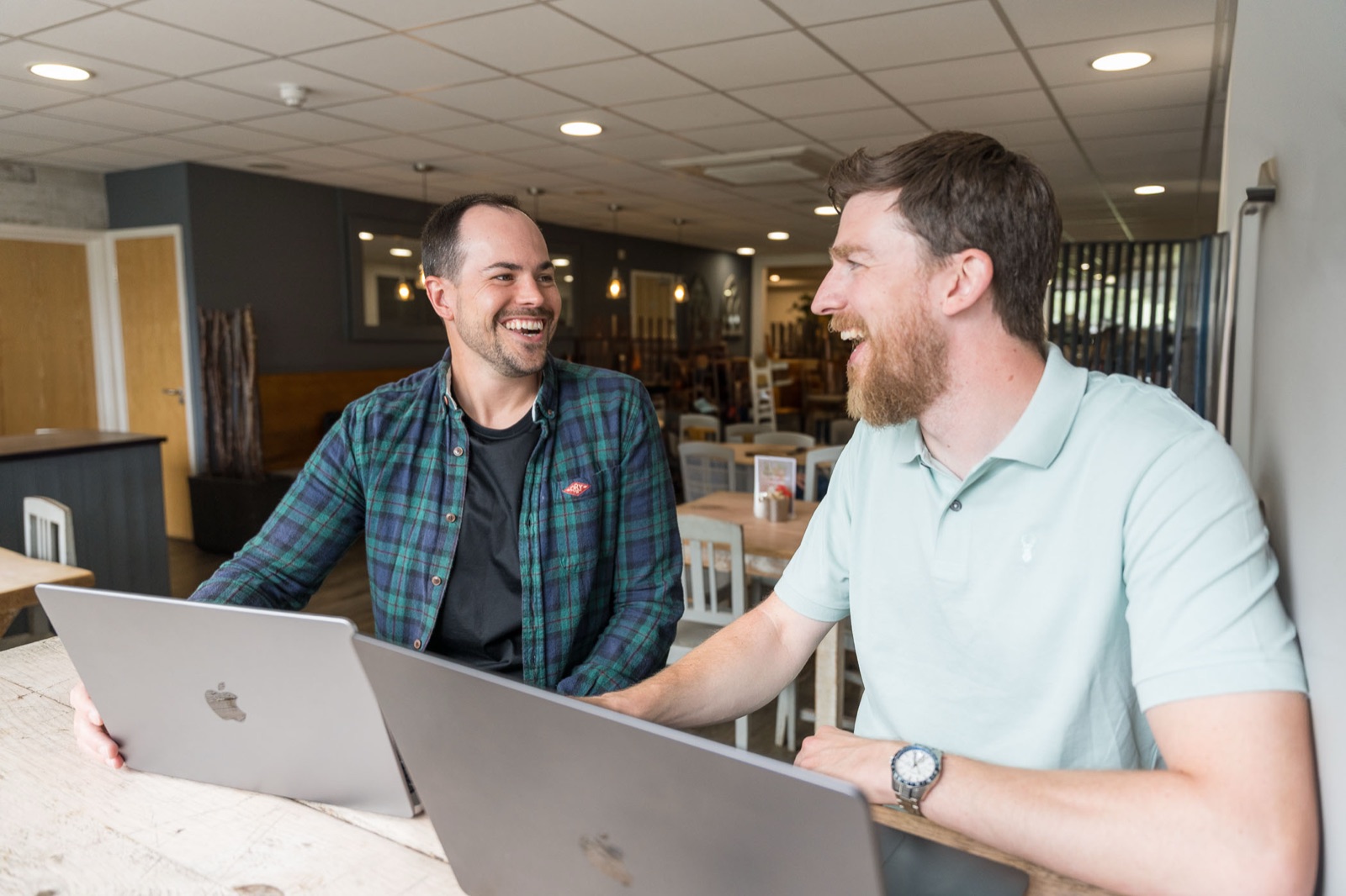 Scott Reynolds of SaaS Success working through a problem with a client, laptops open across a table