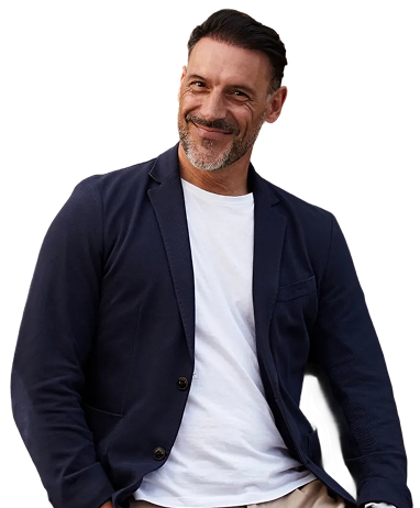 Smiling man in a navy blazer and white t-shirt looking at the camera.