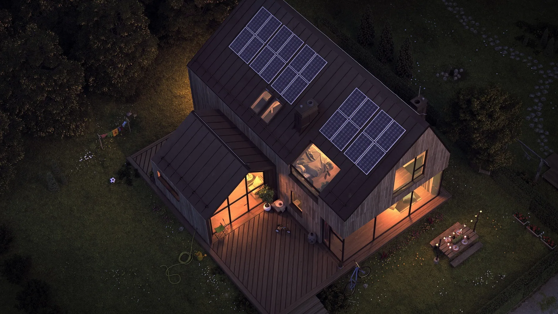 Ein modernes Holzhaus mit PV-Anlage auf dem Dach bei Nacht. Dank Schwarzstartfähigkeit der Batterie brennt trotz Netzausfall Licht.