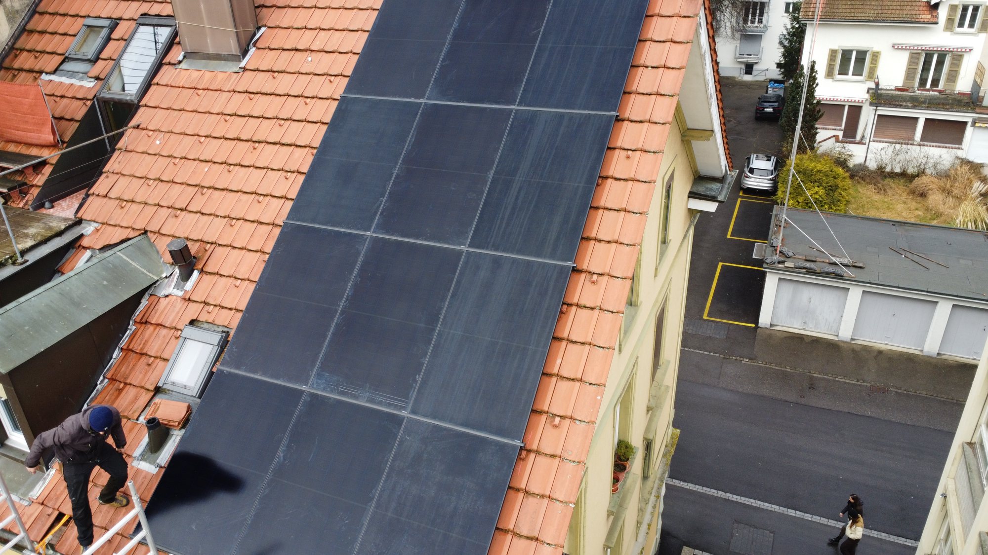 Vollflächige schwarze Aiko-Solaranlage auf einem Bieler Altbau, Drohnenaufnahme