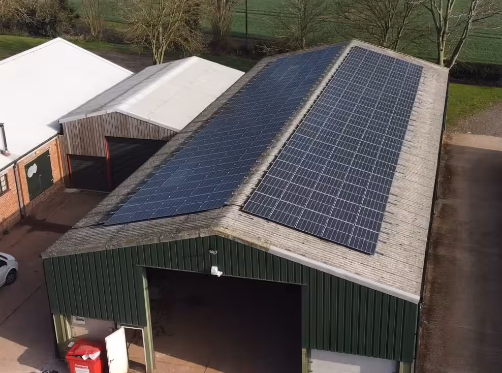 solar pv for business with solar panels mounted on east and west pitch of fibrecement roof of farm grain store