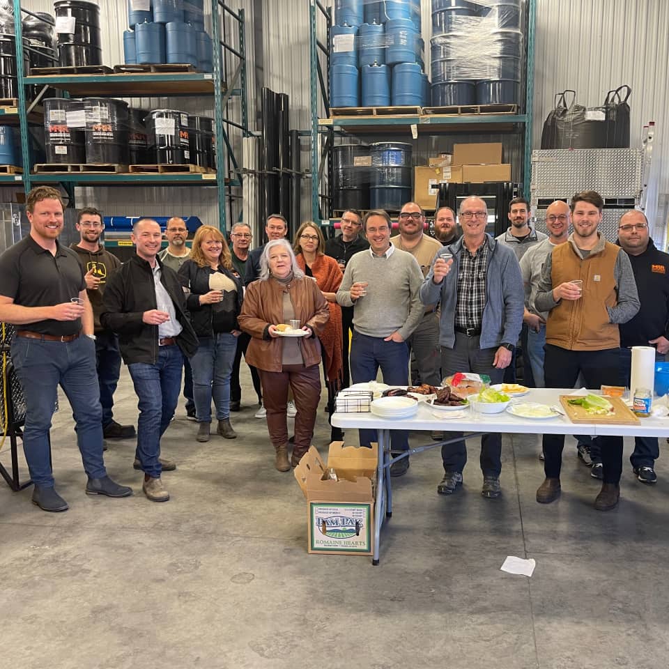 A group of MRR employees gathered indoors for a company celebration, from the timeline