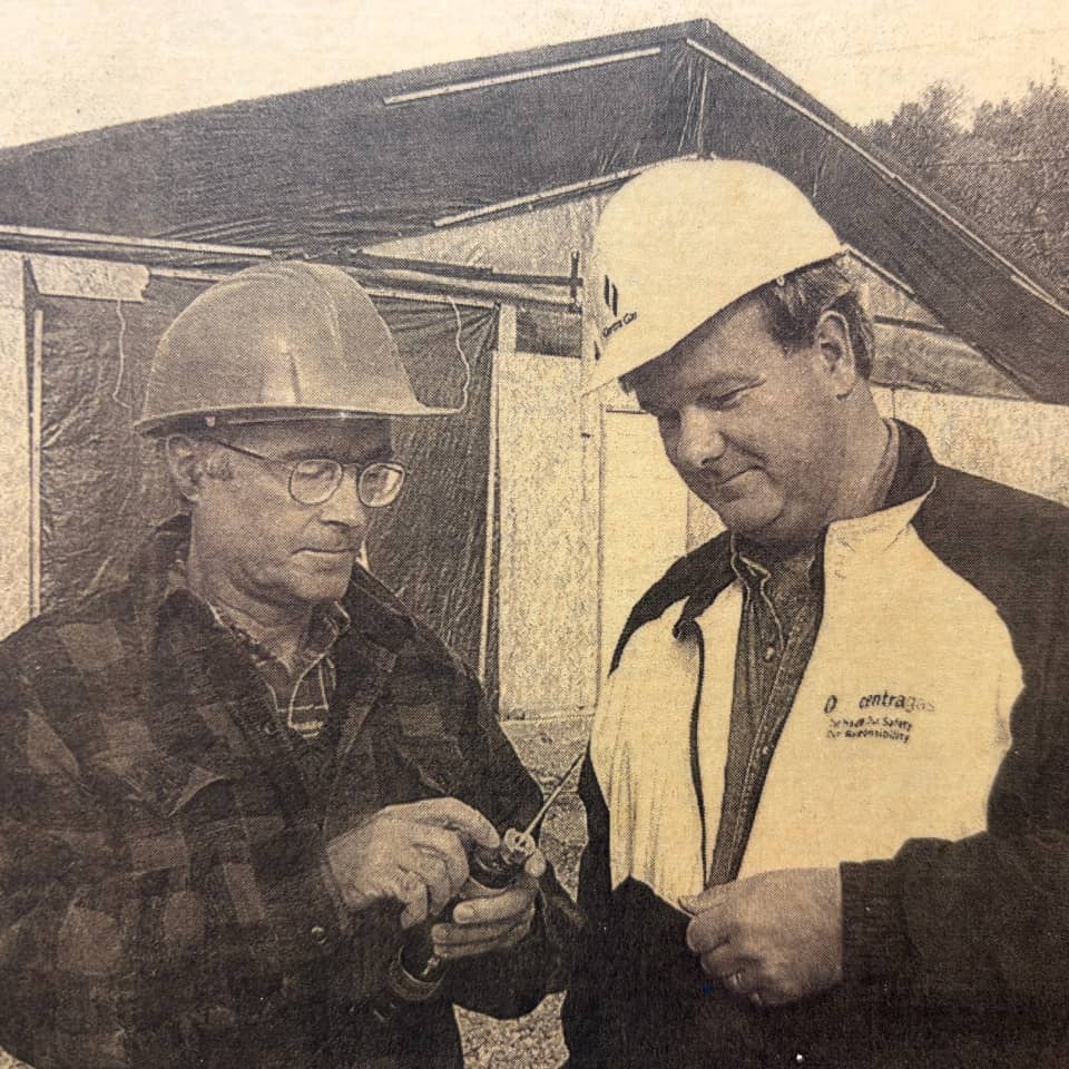 Vintage photo of two MRR field technicians examining odorization equipment, from the company's early history