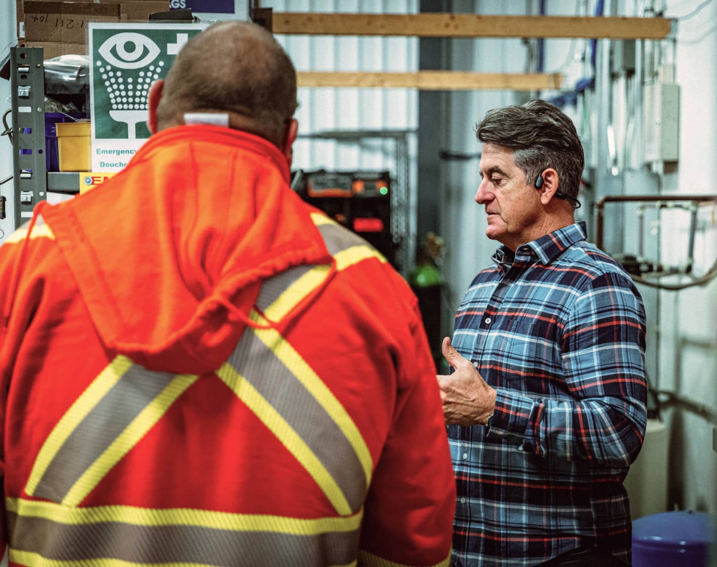 MRR technicians reviewing safety procedures near an eyewash station inside a gas facility