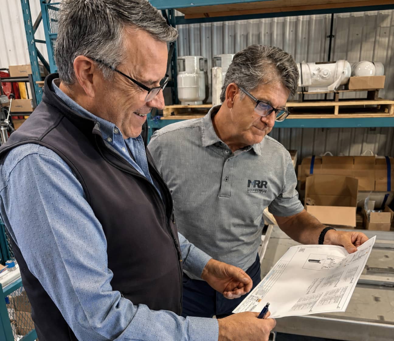Two MRR engineers reviewing project drawings during a system assessment at a facility