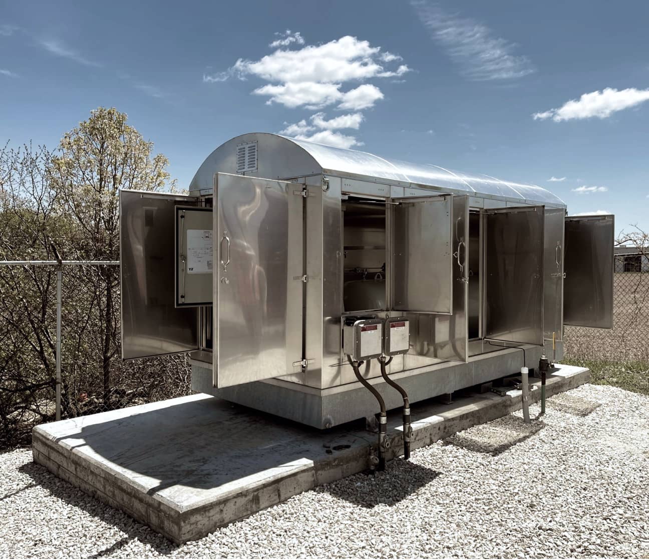 A fully installed MRR odorization equipment enclosure on a concrete pad at a field site