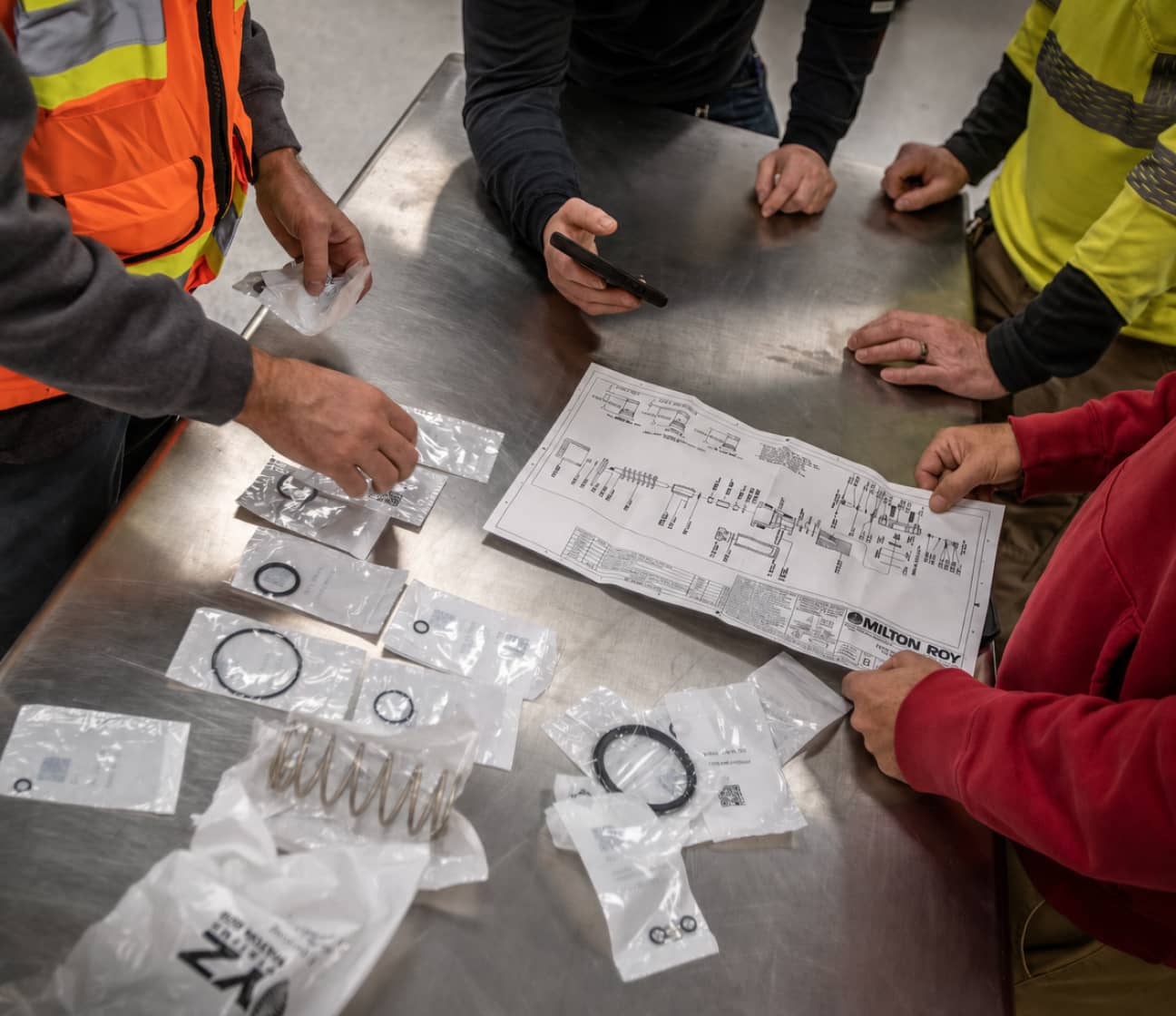 MRR field technicians reviewing system schematics and equipment on a table, representing the Evaluate step