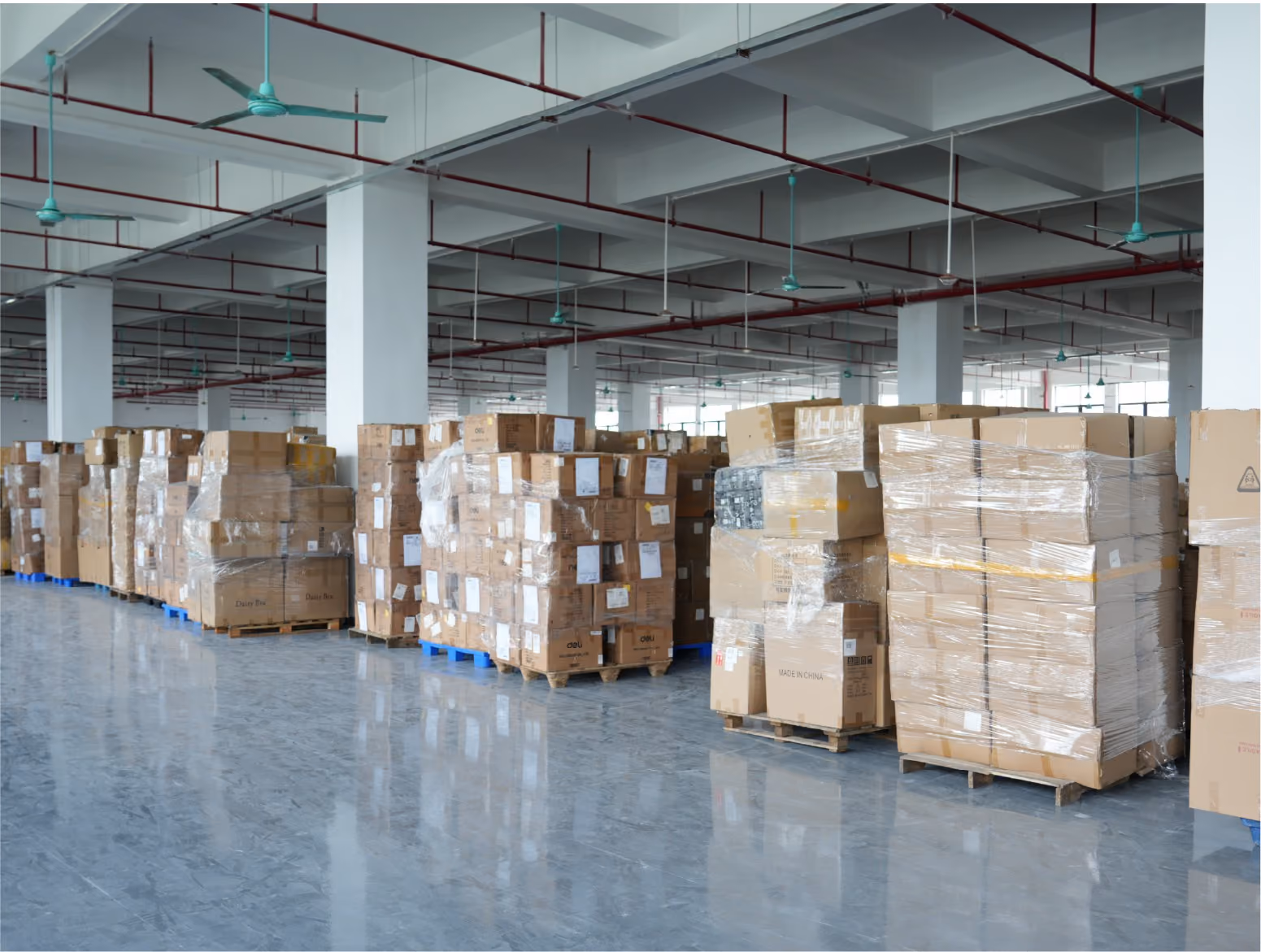 Forklift loading pallets of finished cartons into a shipping container
