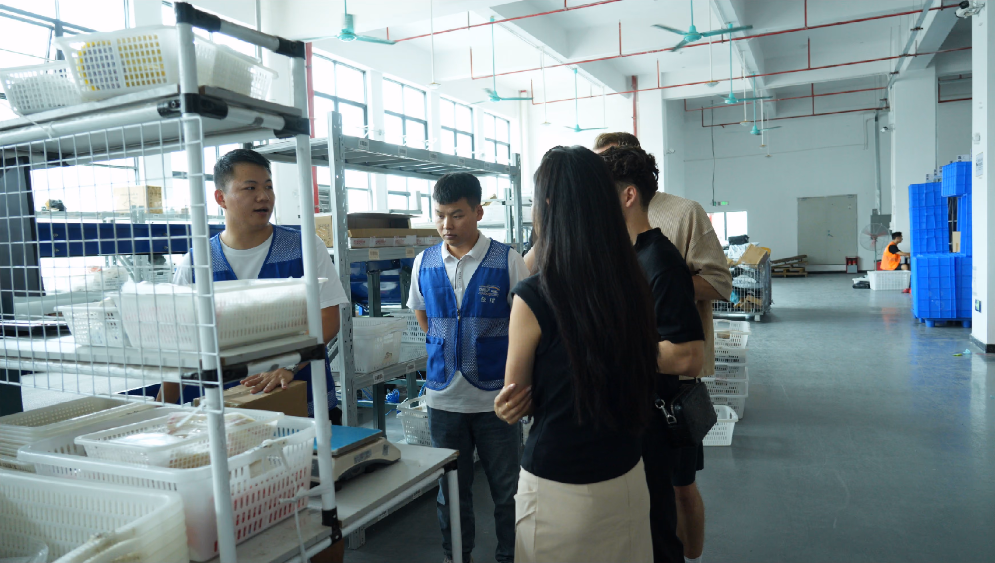 Overseas buyer with an interpreter and engineer discussing equipment on the factory floor