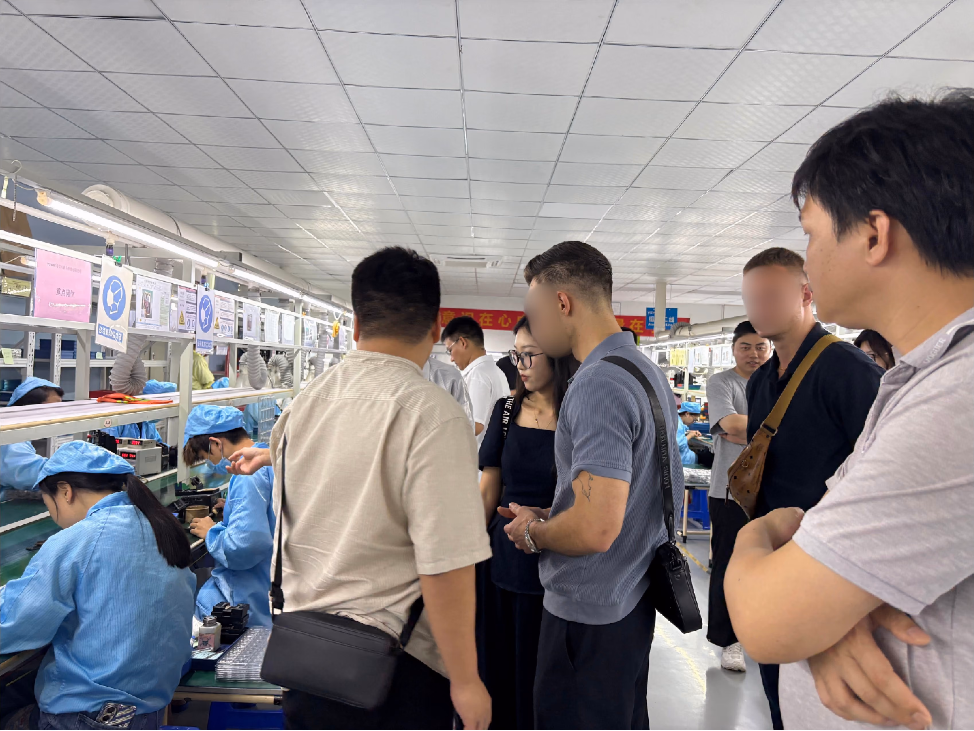 Wide view of a factory floor with rows of production machines and workers