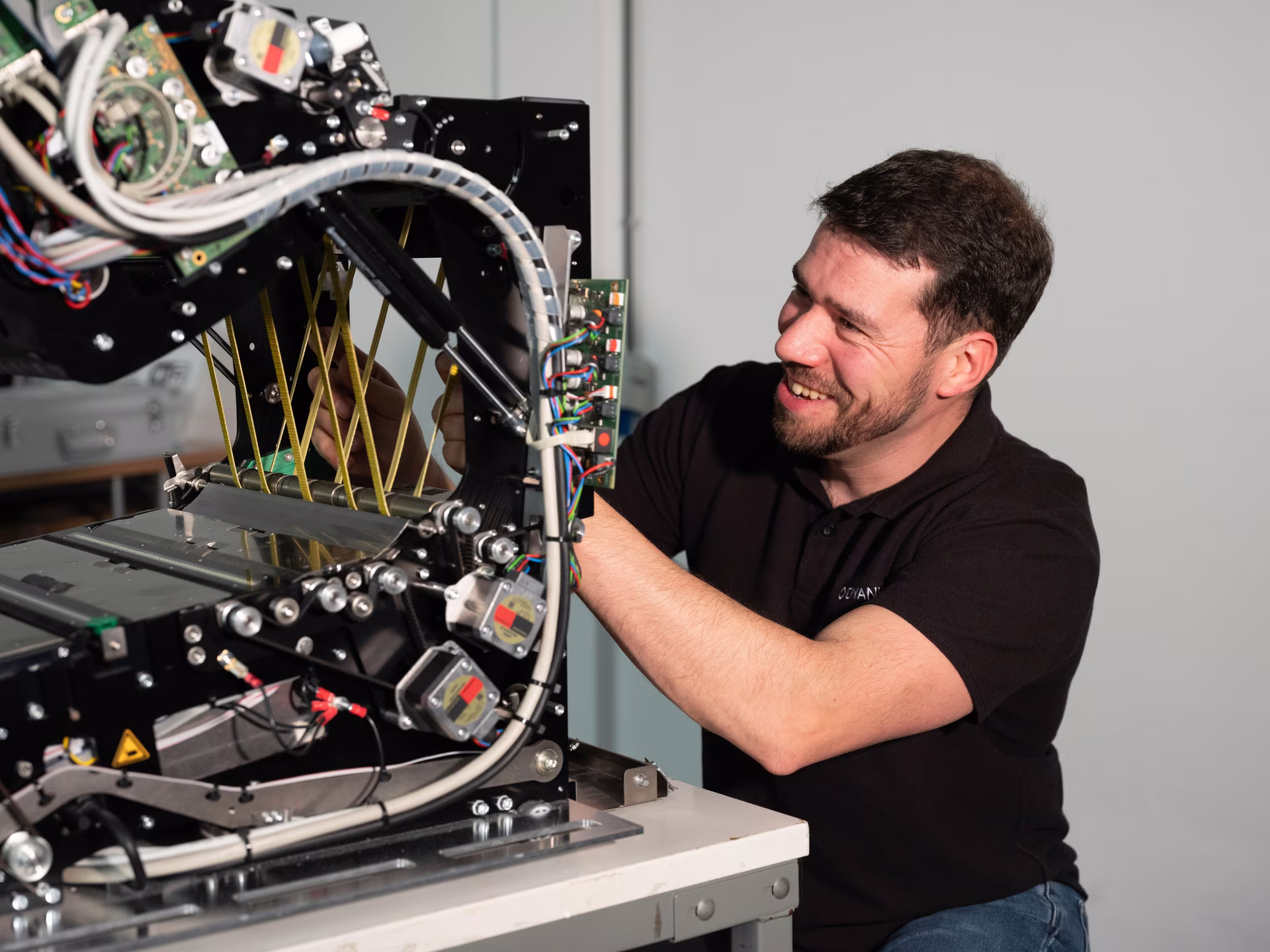 Dyanix service engineer working on the opened transport unit of a production scanner