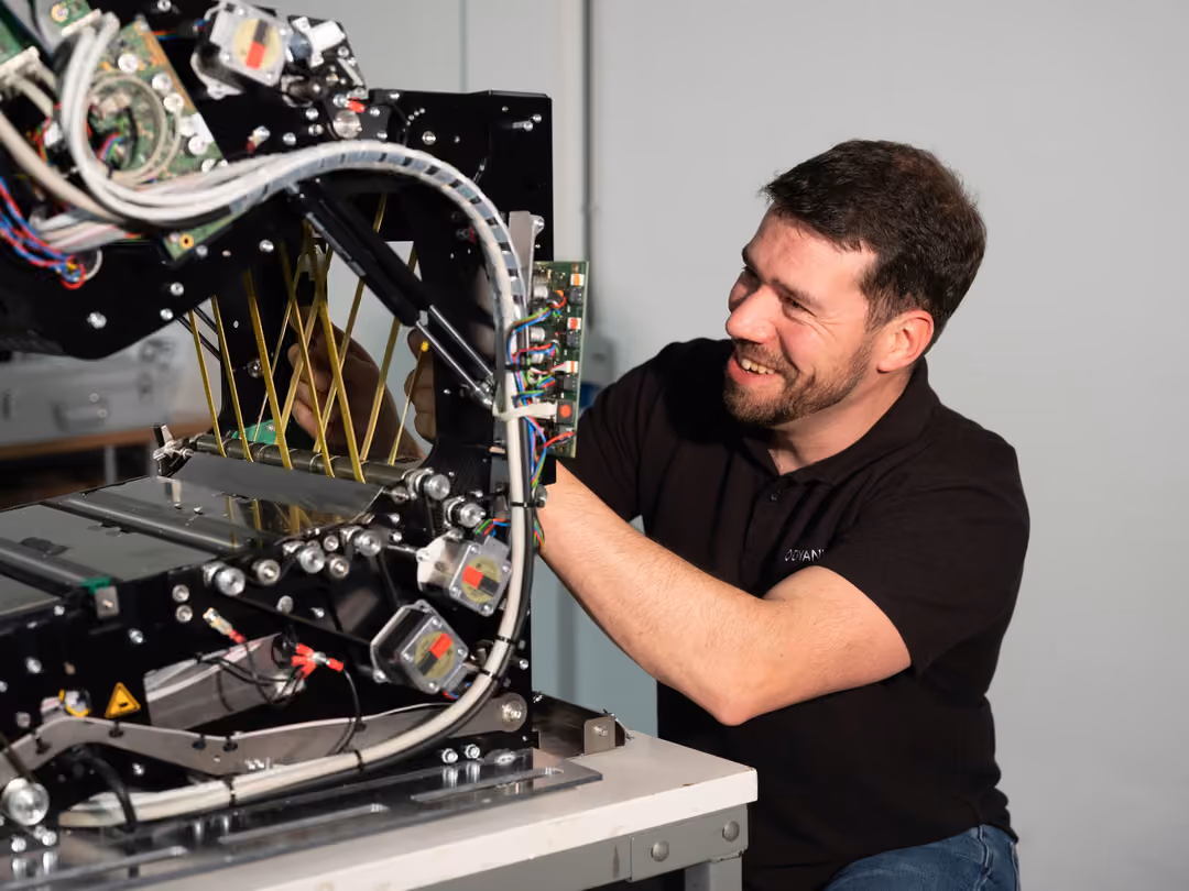 Dyanix service engineer working on the opened transport unit of a production scanner