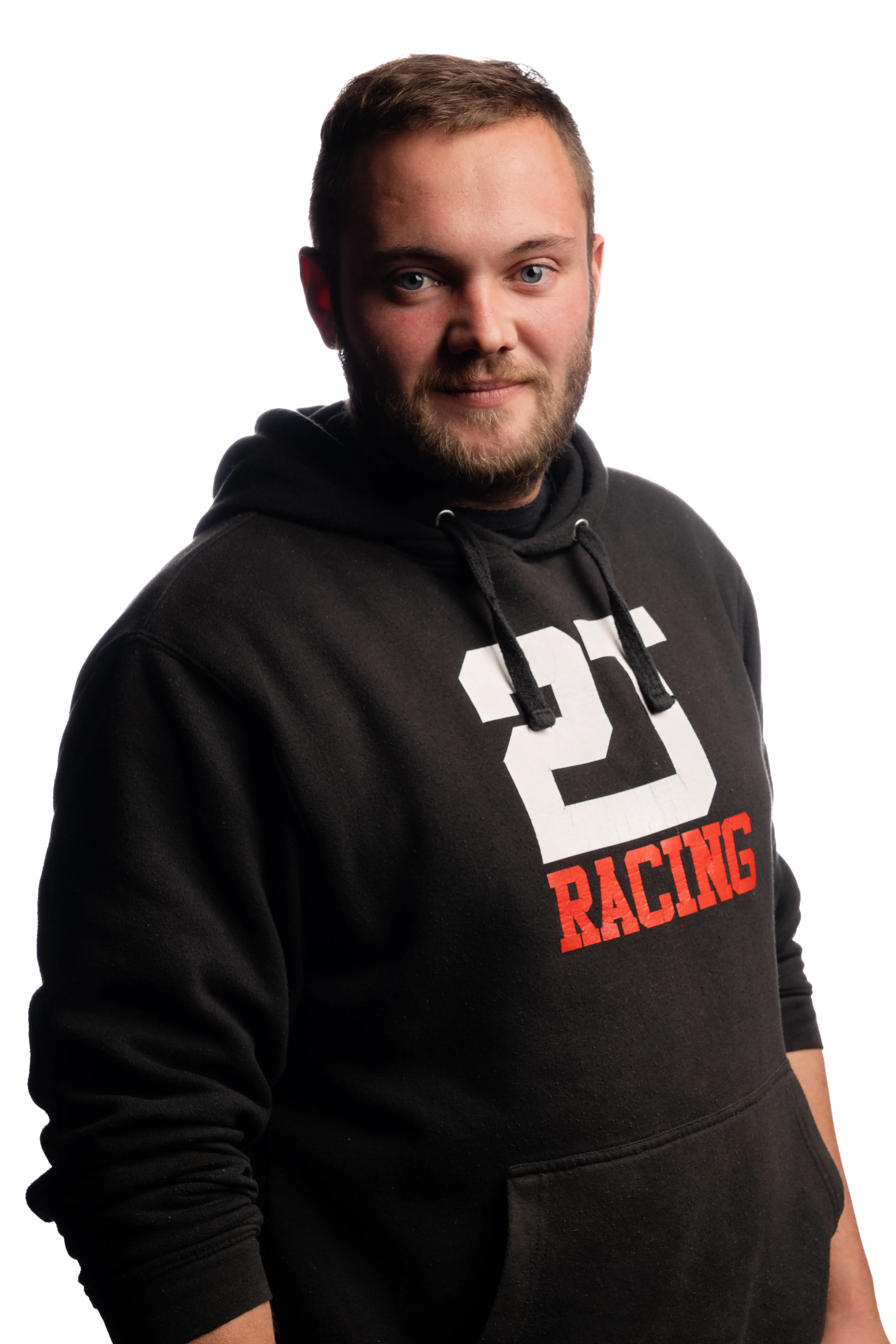 Jeune homme avec barbe portant un sweat à capuche noir avec le texte blanc et rouge '25 Racing'.