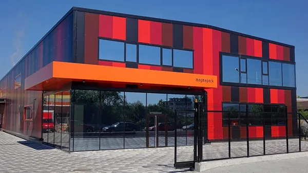Modern building with a red and black striped facade and a glass entrance.