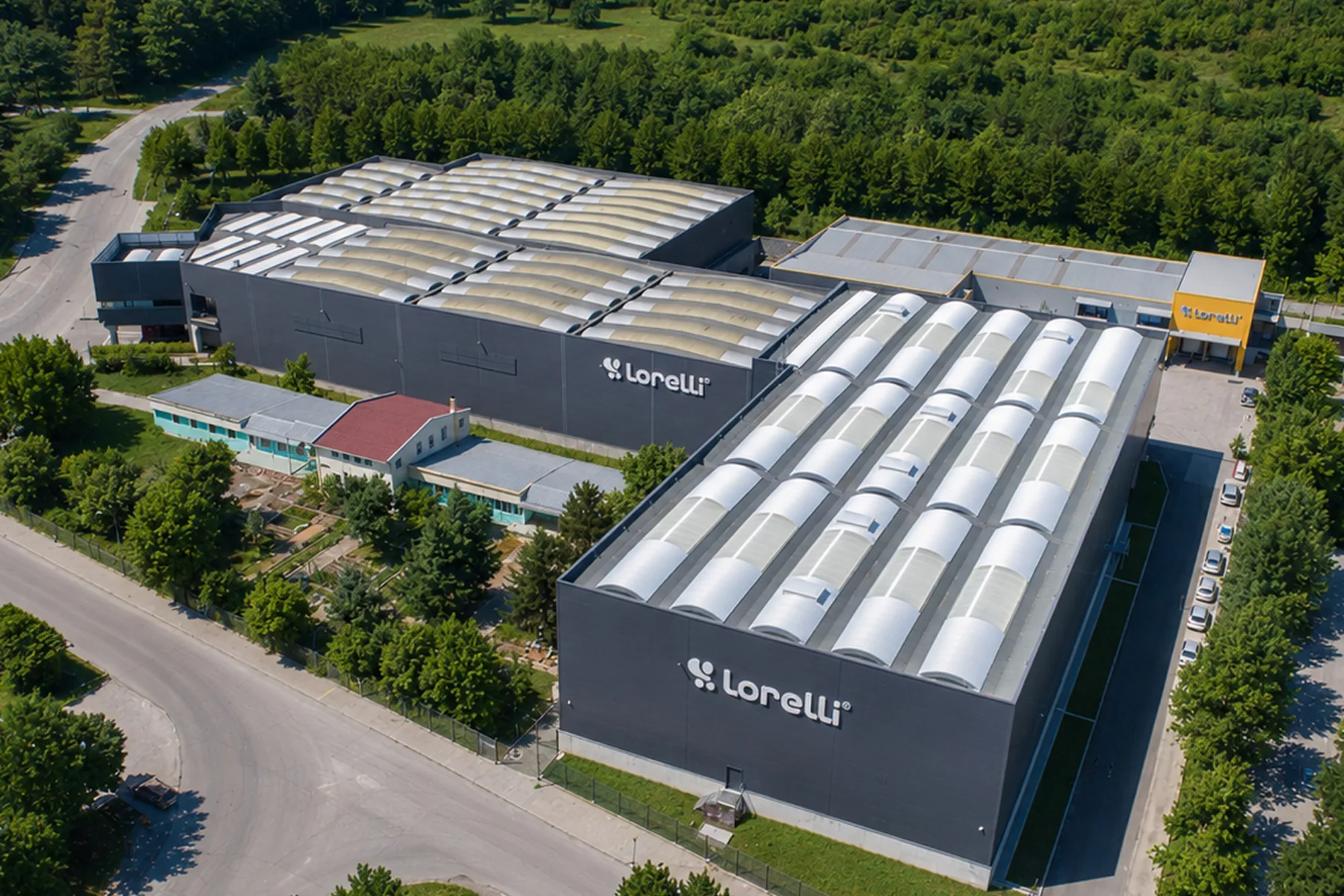 Aerial view of the Lorelli factory complex surrounded by trees.