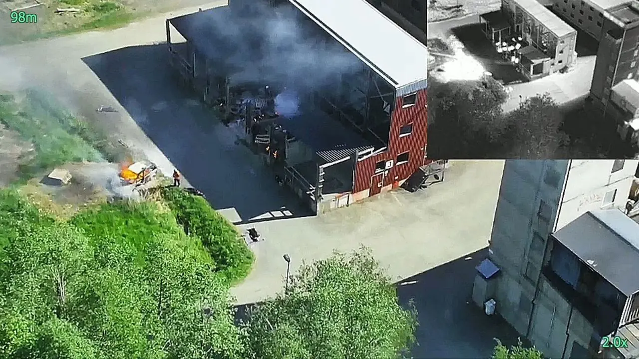 LiveView from the aircraft during an exercise: an aerial view of a building with smoke, with a thermal image inset