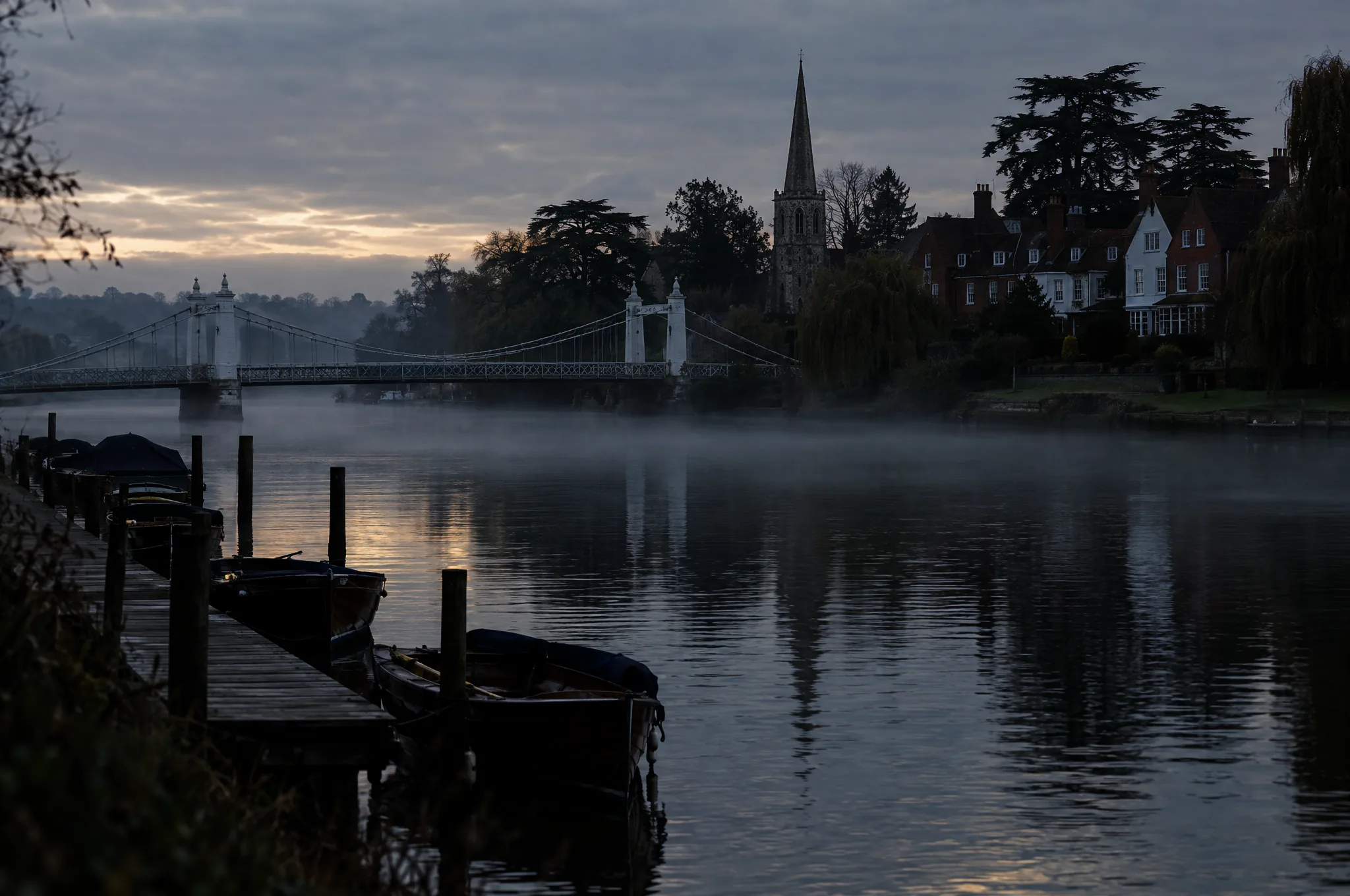 A suspension bridge over the Thames at Marlow on a misty morning
