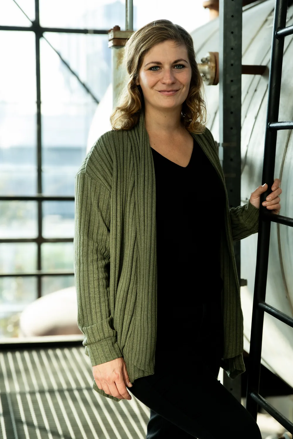 Esther Overbeeke van Buro Staal in een groen vest bij een stalen ketel in een industriële hal