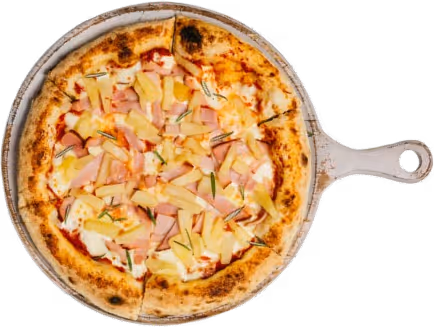 Hawaiian pizza with ham, pineapple, and rosemary on a wooden serving board.