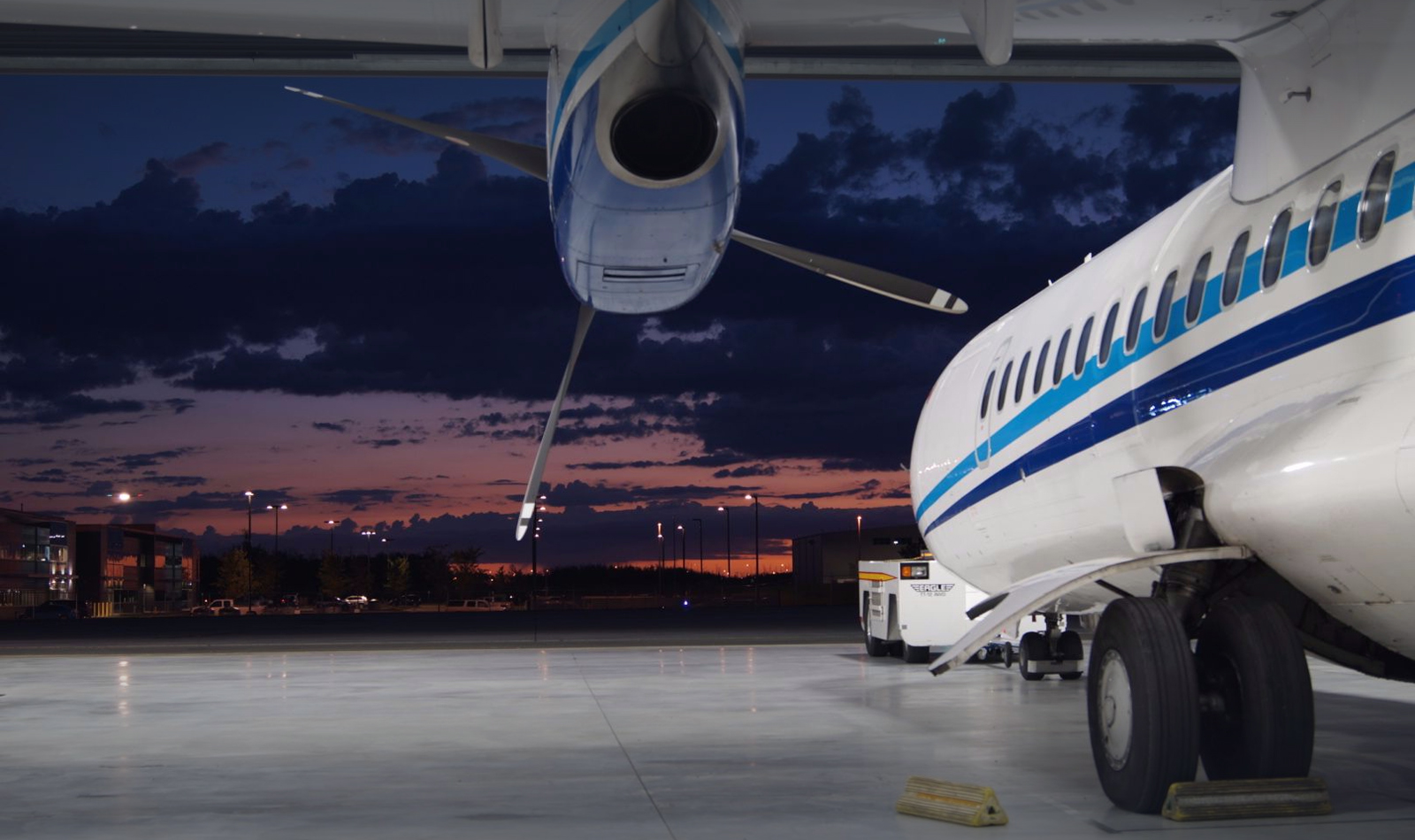 Private jet engine and landing gear on an airport apron at twilight
