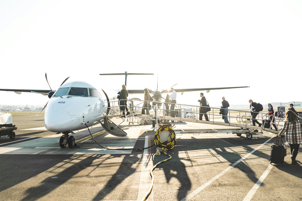 Passengers boarding a regional turboprop aircraft via an airport ramp