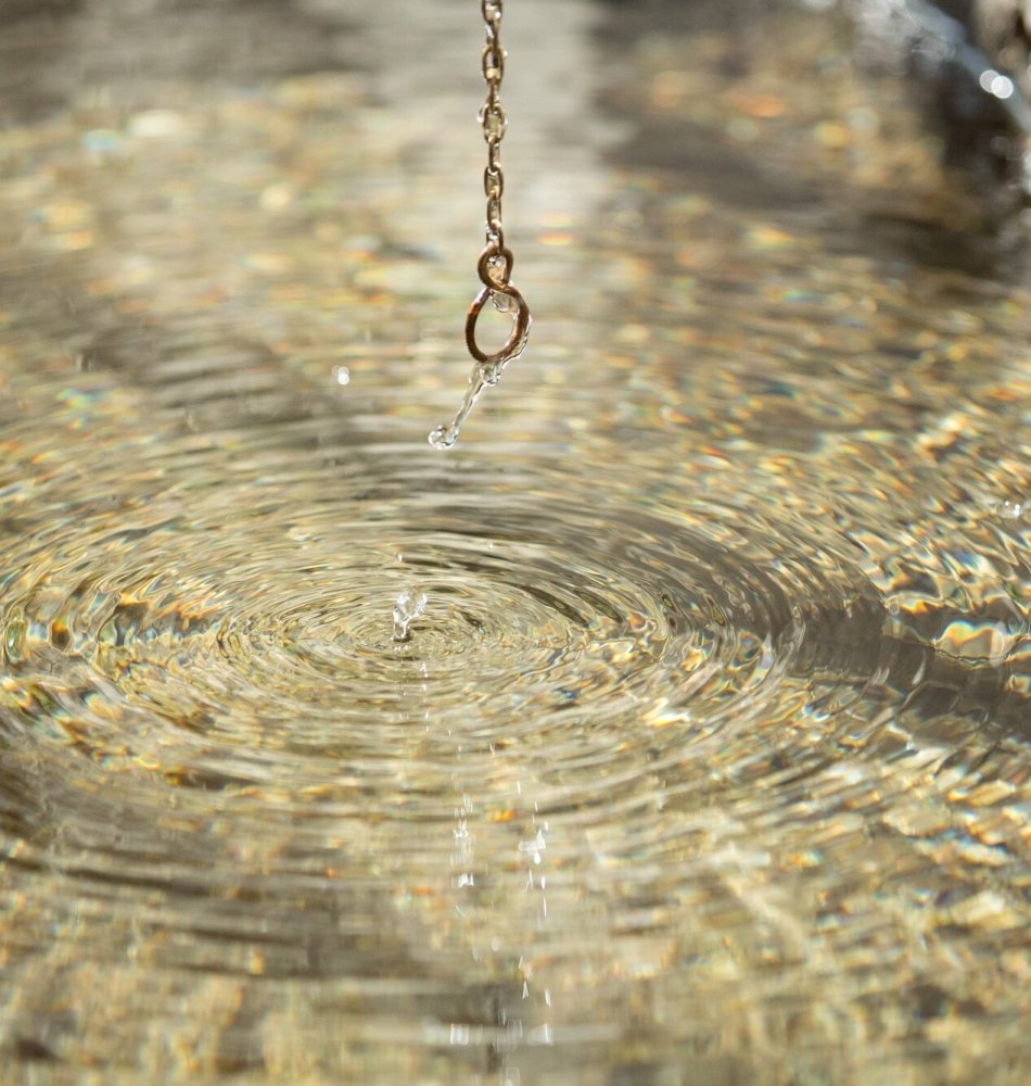 A drop of water falling onto a calm water surface, fountain in the orangery at the Tannerhof