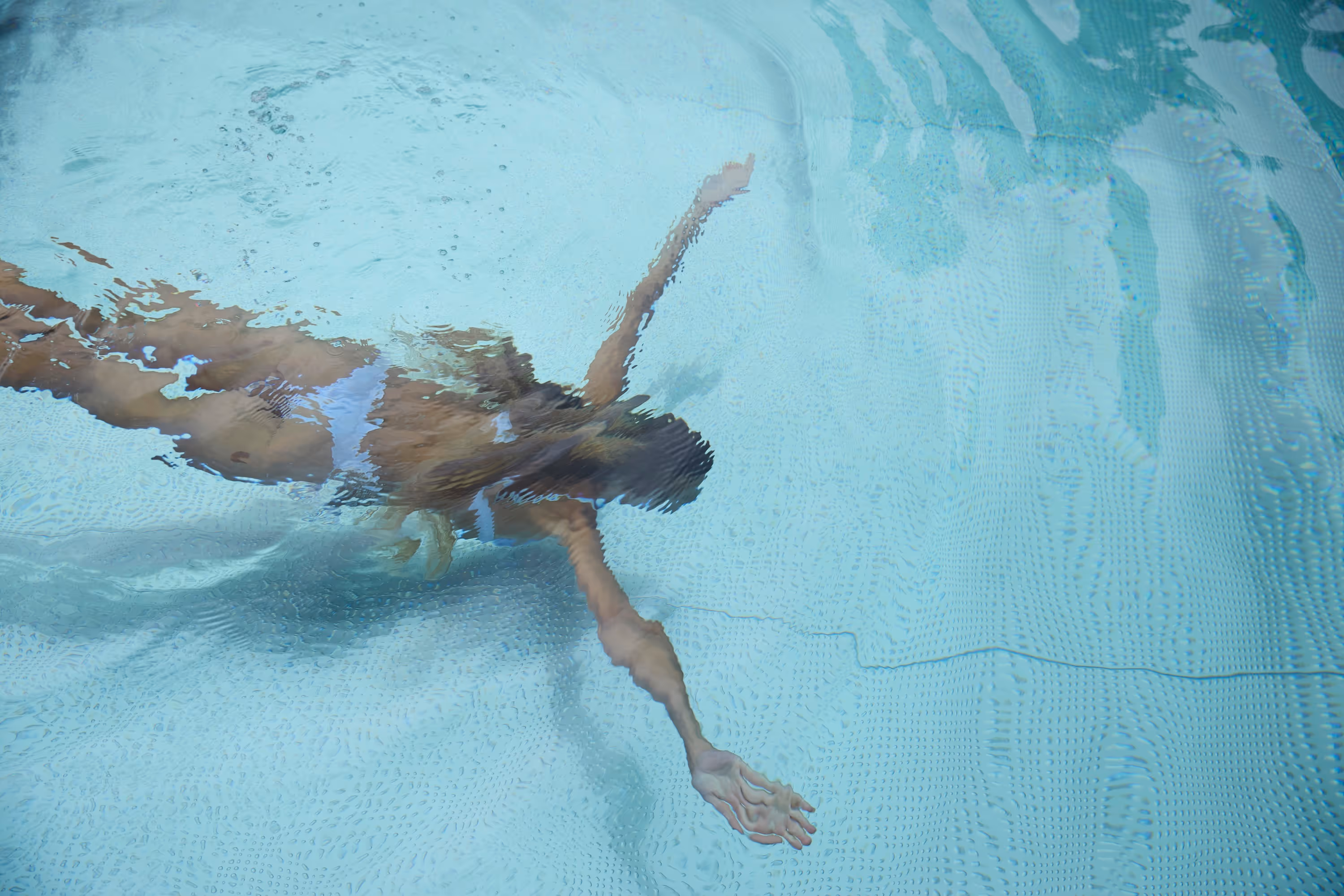 A person swims laps in the 25-metre stainless-steel outdoor natural pool at Naturhotel Tannerhof in Bayrischzell.