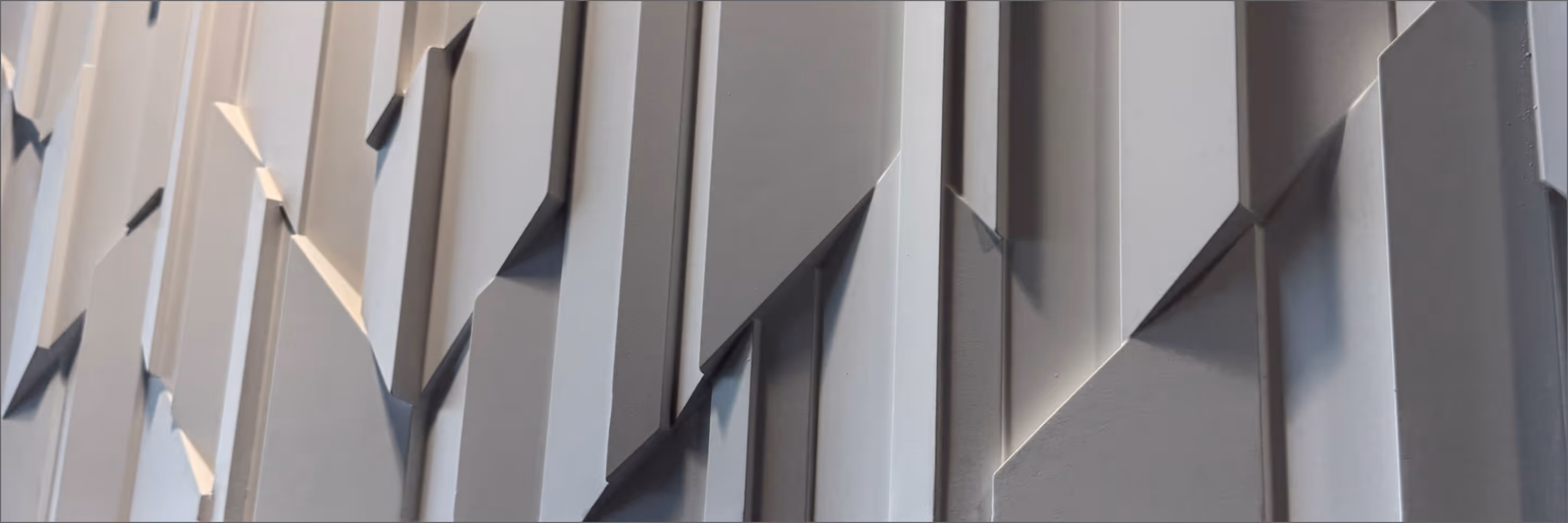 Gray textured abstract geometric wall with layered rectangular panels and shadows.