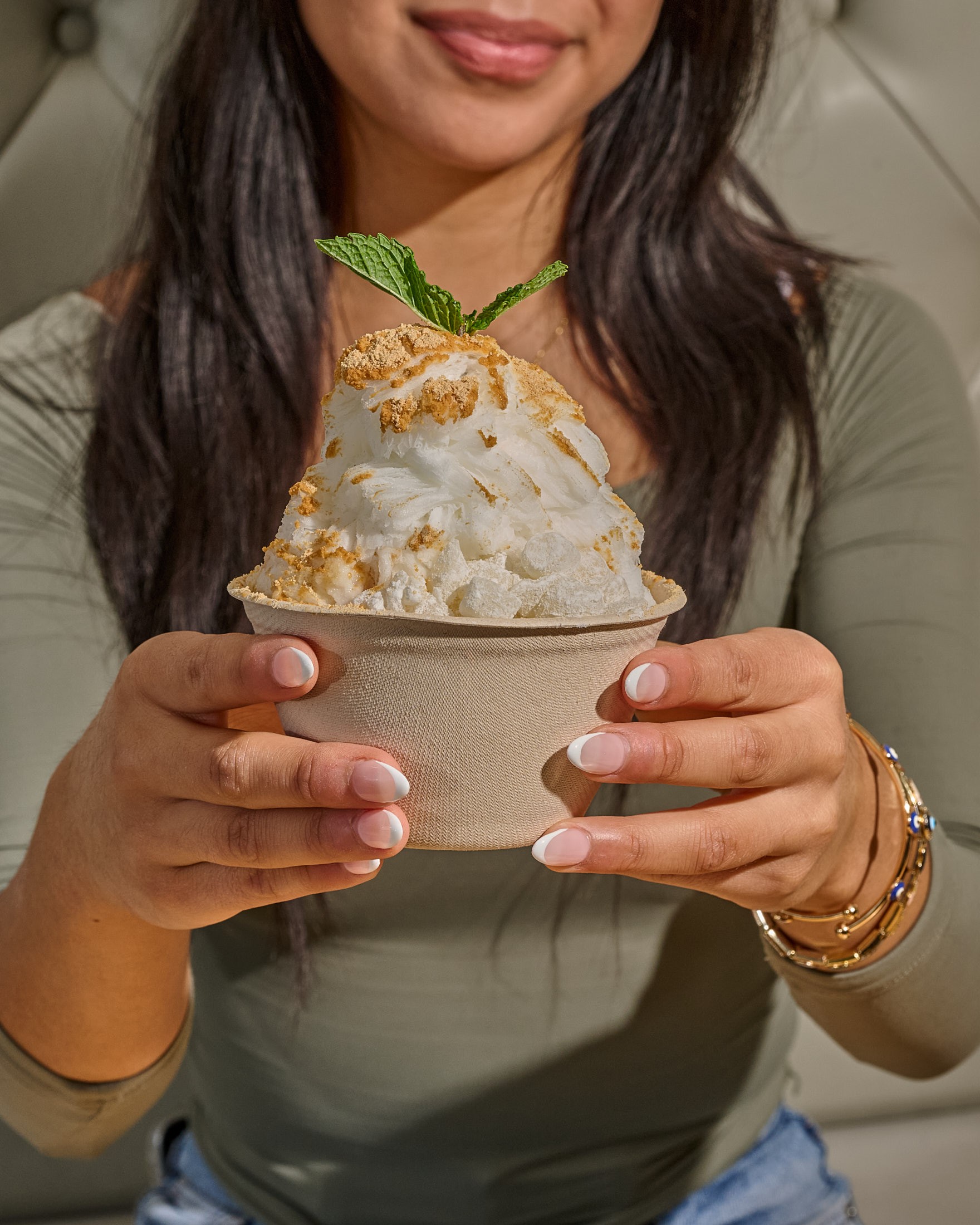 A guest holding an injeolmi bingsu bowl with both hands before starting to eat