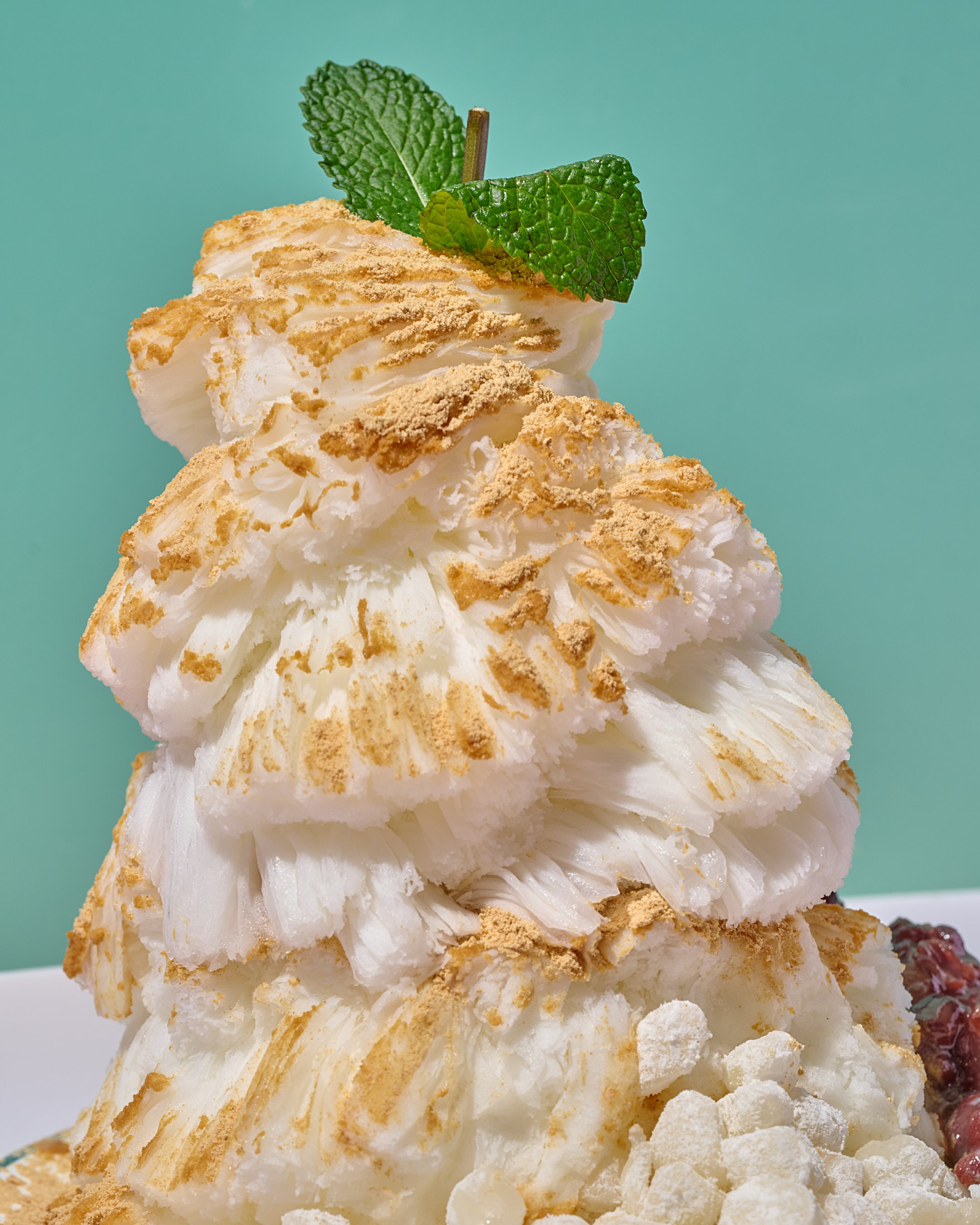 Close-up of Oakobing injeolmi bingsu texture, snow-fine shaved milk ice rather than water ice