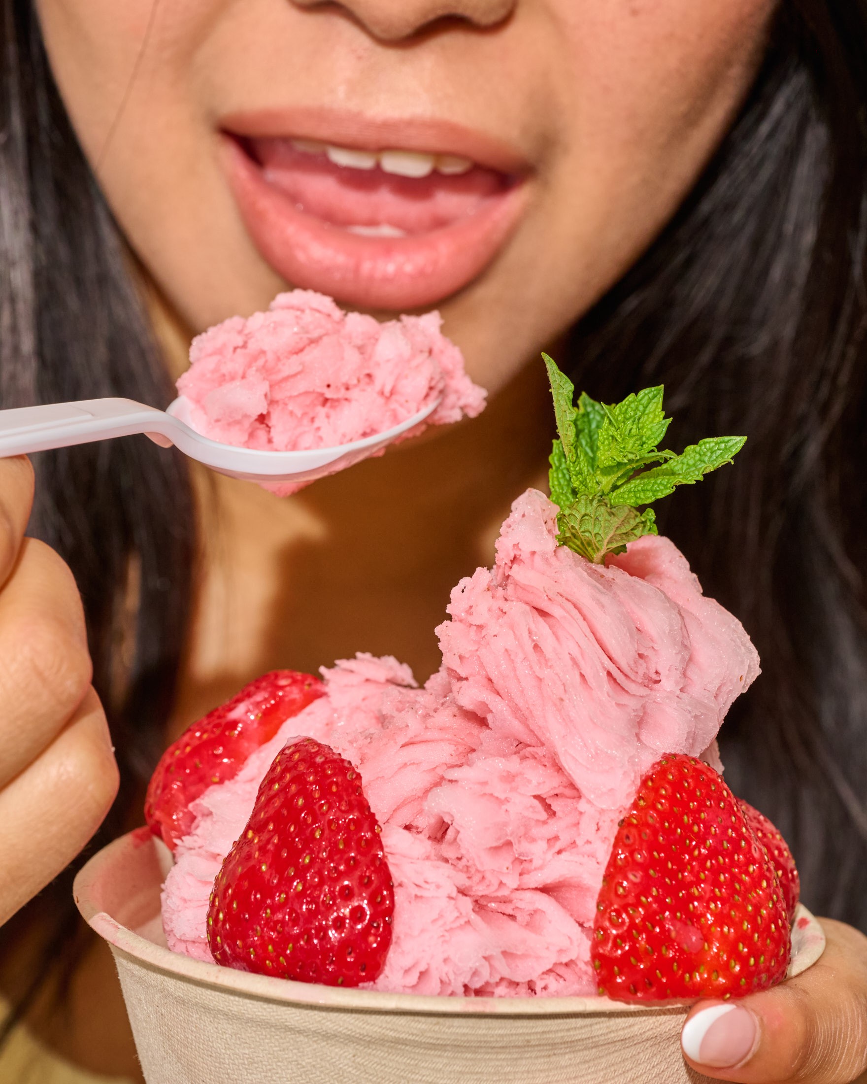 A spoonful of strawberry bingsu lifted from a shared bowl at an Oakobing cafe