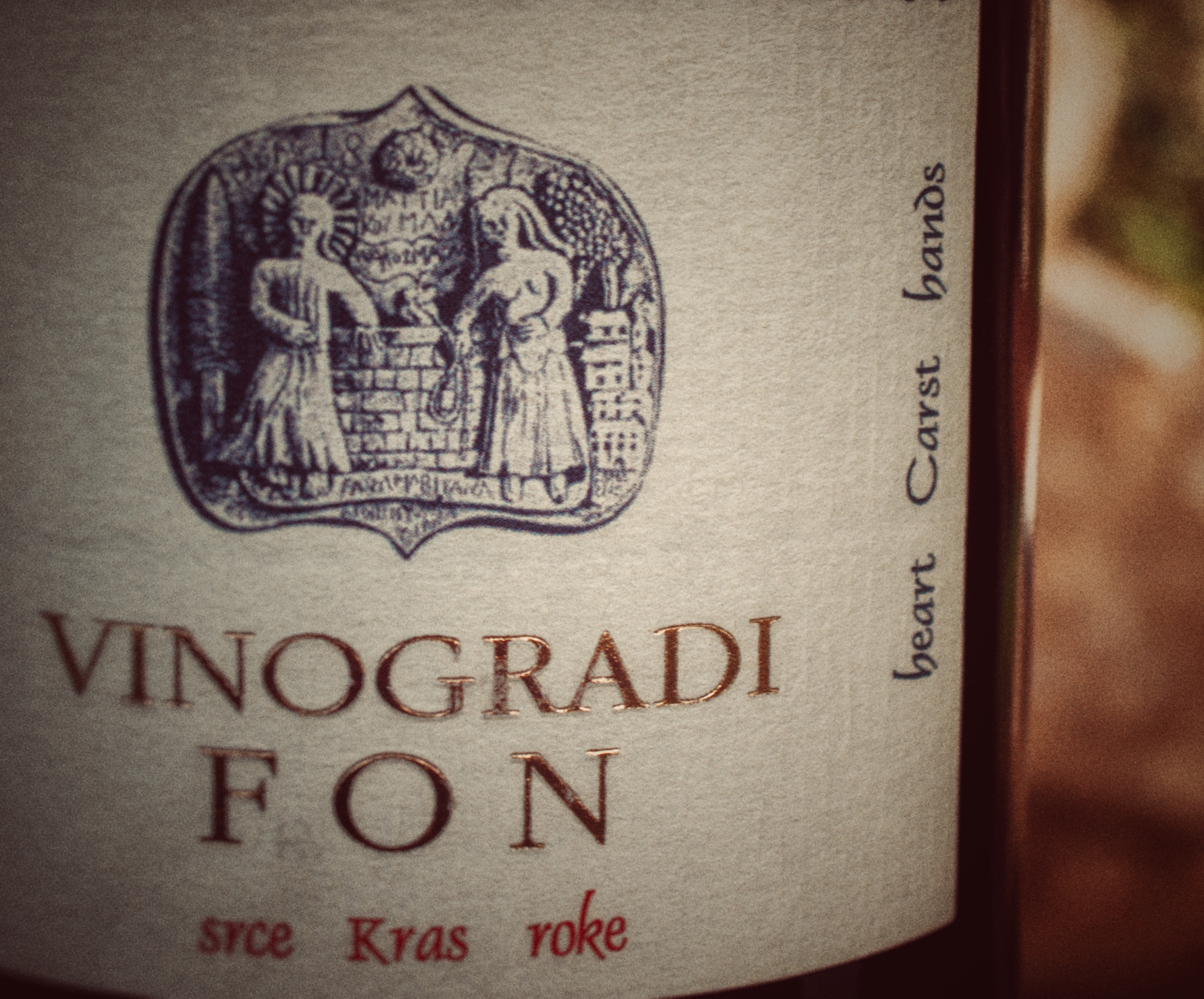 Wine label 'Vinogradi Fon' with an emblem showing two figures by a brick wall and text 'heart Carst hands'.