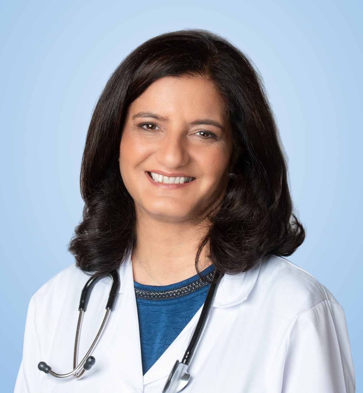 Dr. Mudita Malhotra, board-certified family physician, smiling in her white coat and stethoscope