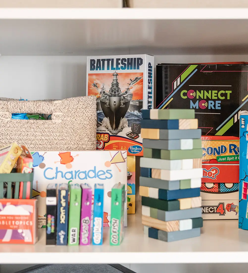 Family therapy game shelf with Battleship, Charades, and Jenga used for connection-building sessions