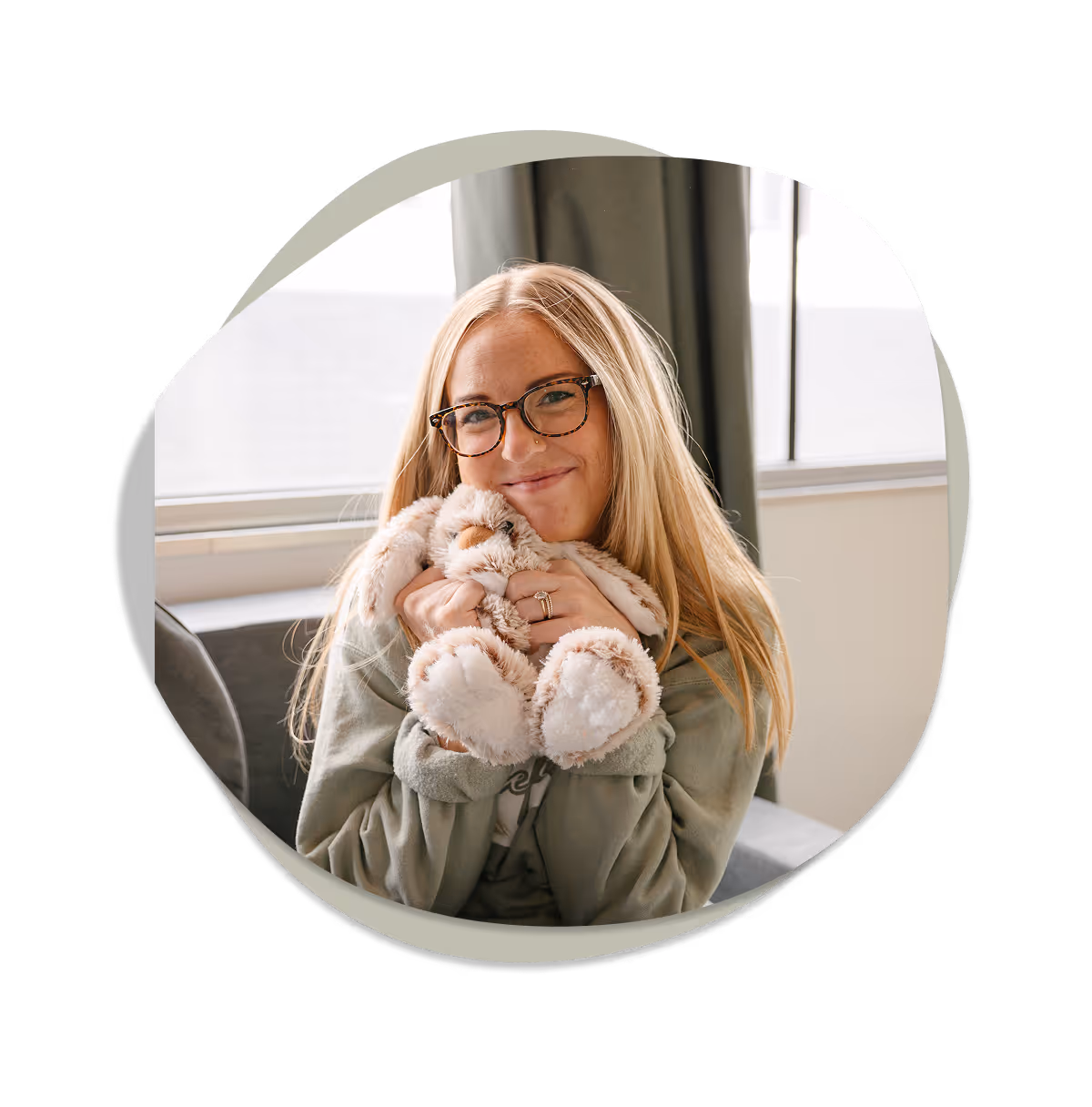 Play therapist at Playful Pathways in Berkley Michigan smiling and holding a plush bunny used in attachment-focused play therapy