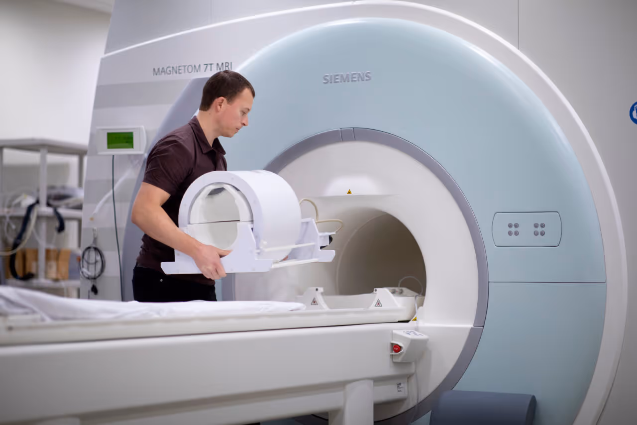 Image of a technician placing the specialized head cradle into the MRI machine for a scan