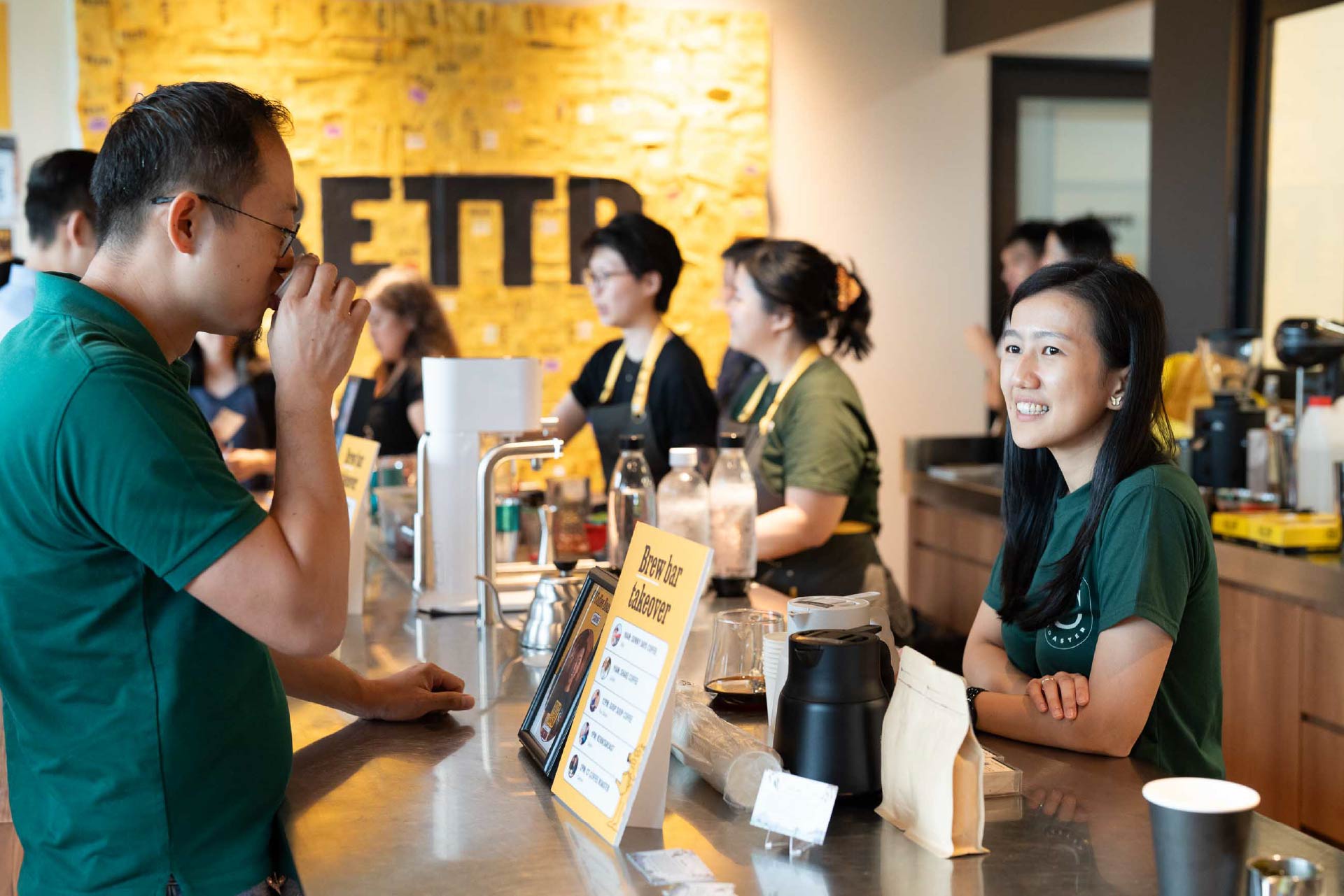 Person serving coffee at the bar.