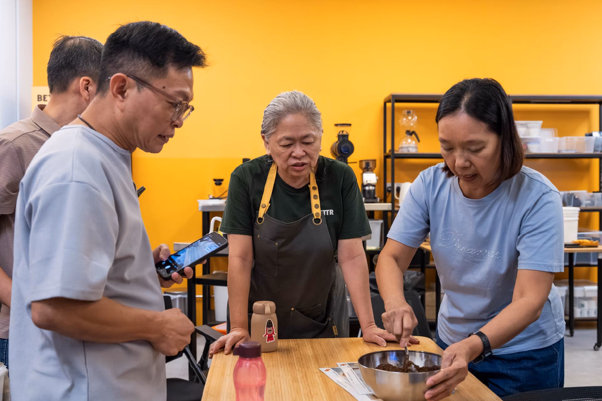 Trainer giving instructions to students on how to make coffee scrub.