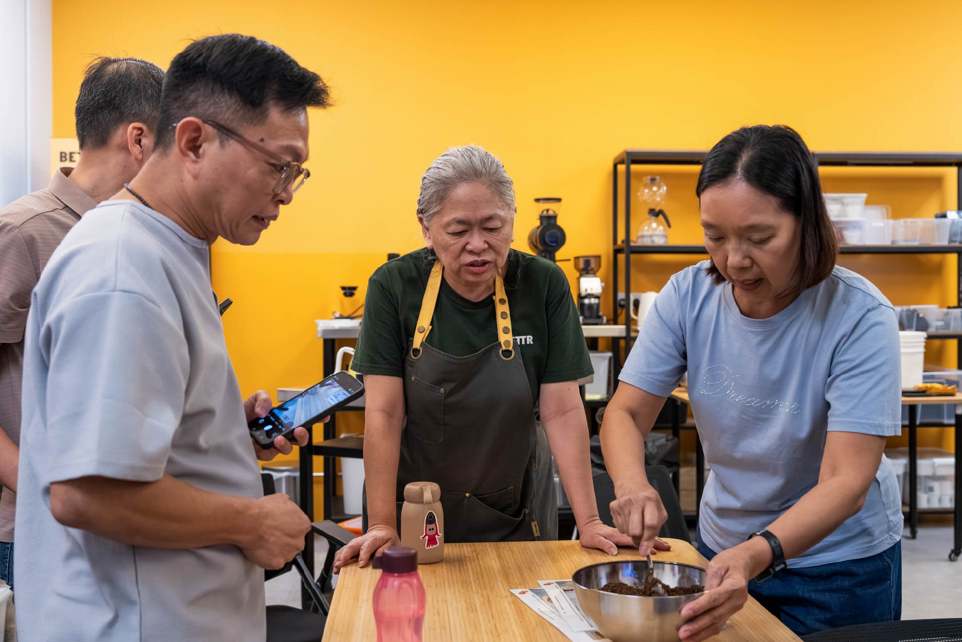 Trainer giving instructions to students on how to make coffee scrub.
