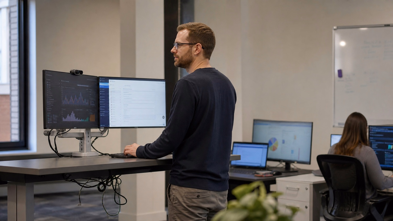 IT professional reviewing computer screen at standing desk 61 chars